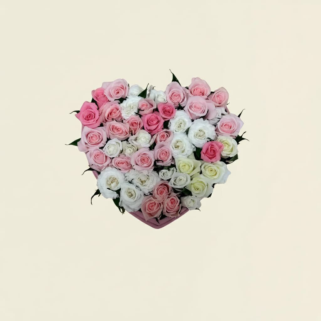 top view of roses filling the large pink heart shape box with white and pink petals
