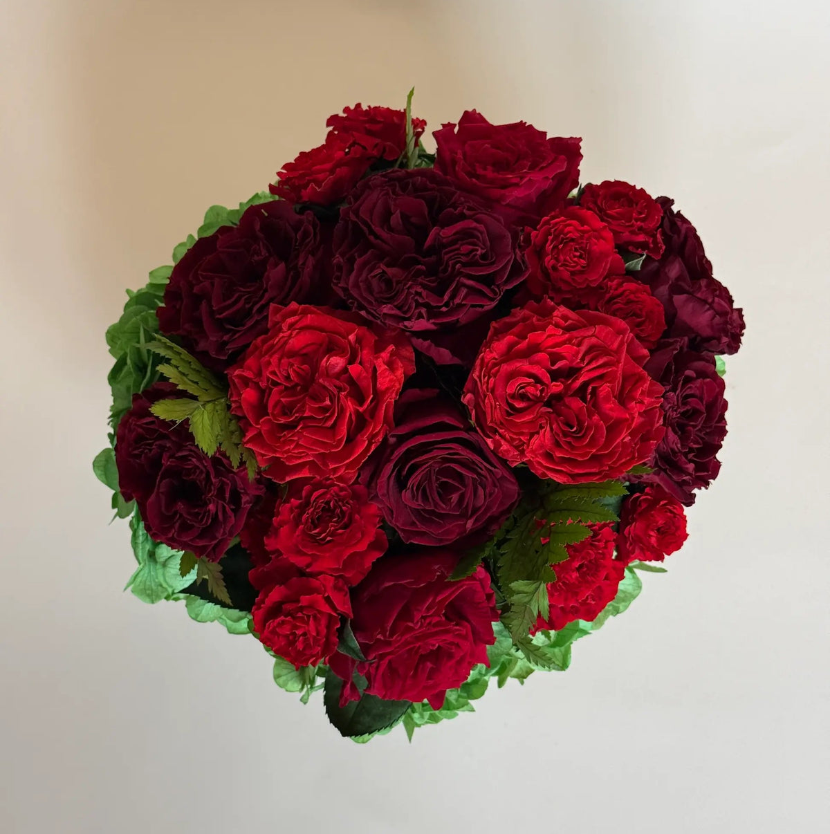 top view of hydrangeas and roses forming a rounded dome in a small black hat box