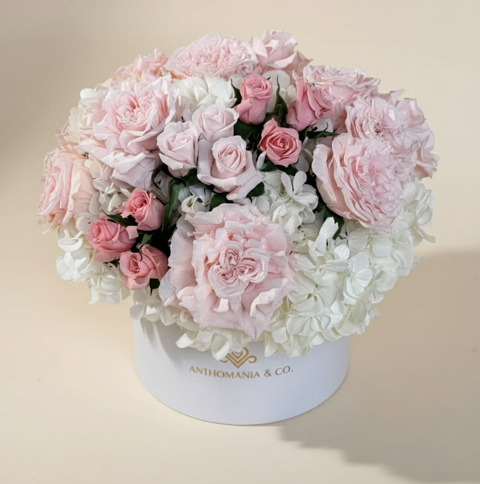 side view of hydrangeas and roses arranged in a dome inside the white large hat box
